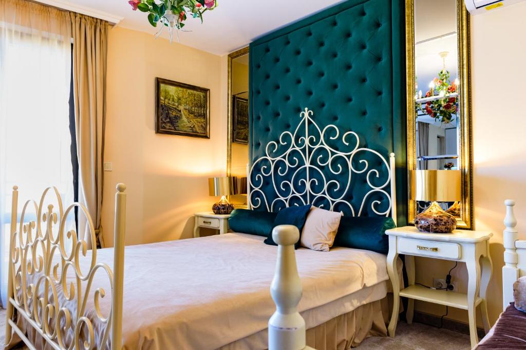 a bedroom with a large bed with a blue headboard at CASA ARTA in Burgas