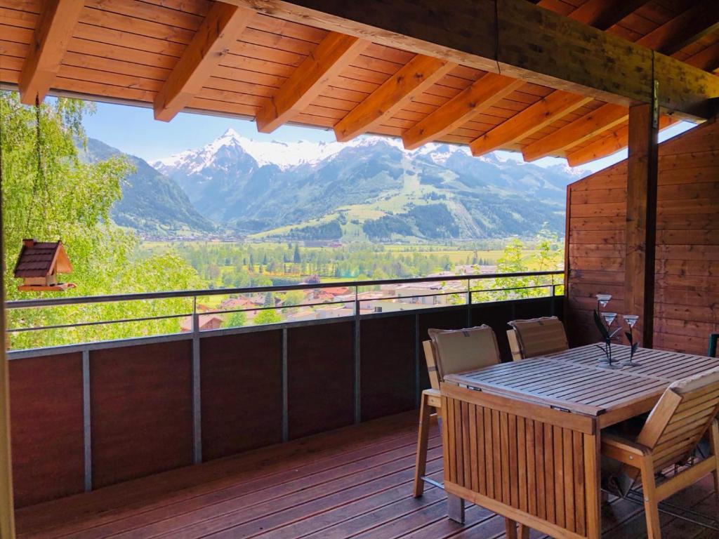 une terrasse avec une table, des chaises et des montagnes dans l'établissement Penthouse Bruckberg by Four Seasons Apartments, à Zell am See