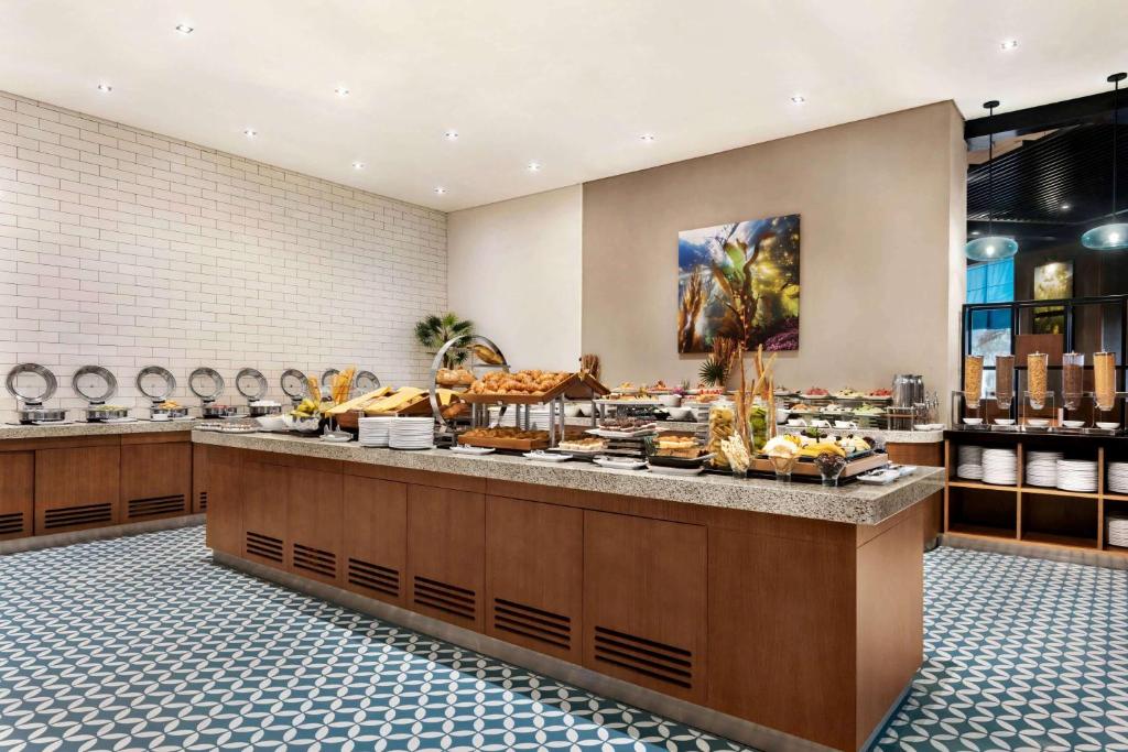 a bakery with a buffet of food on display at Wyndham Garden Ajman Corniche in Ajman 