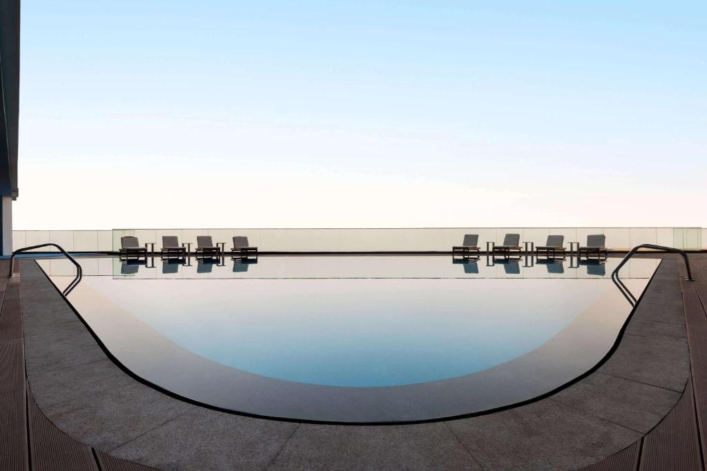 a bath tub in a room with a large window at Wyndham Garden Ajman Corniche in Ajman 
