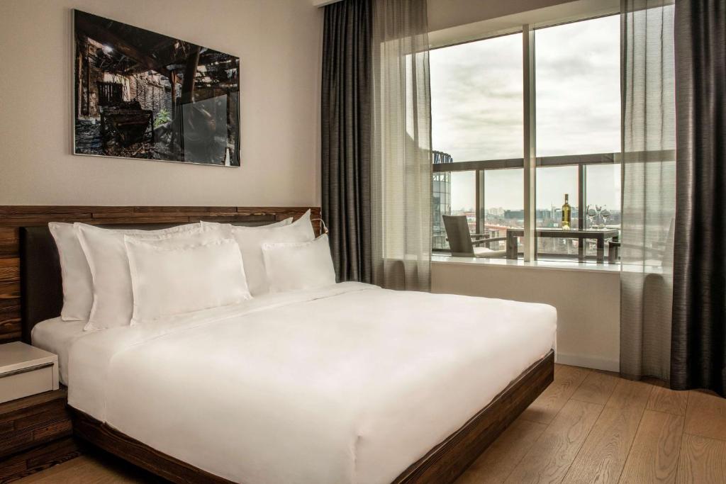 a bedroom with a white bed and a large window at Radisson Collection Hotel, Old Mill Belgrade in Belgrade