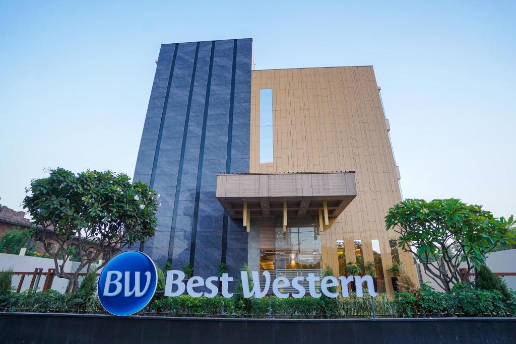 een gebouw met een blauw beste westers bord ervoor bij Best Western Vrindavan in Vrindāvan