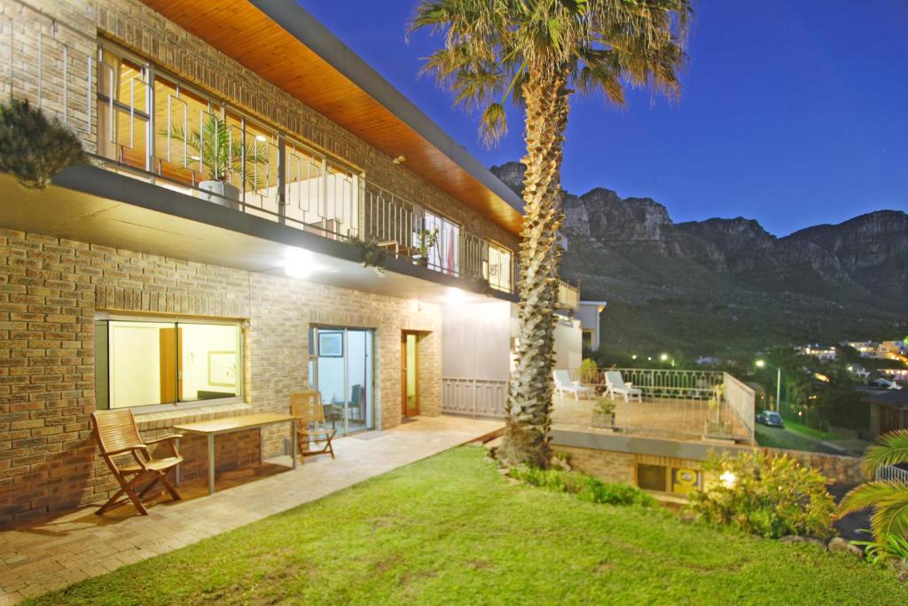 a patio with a table and a palm tree at Guest House Michelitsch in Cape Town