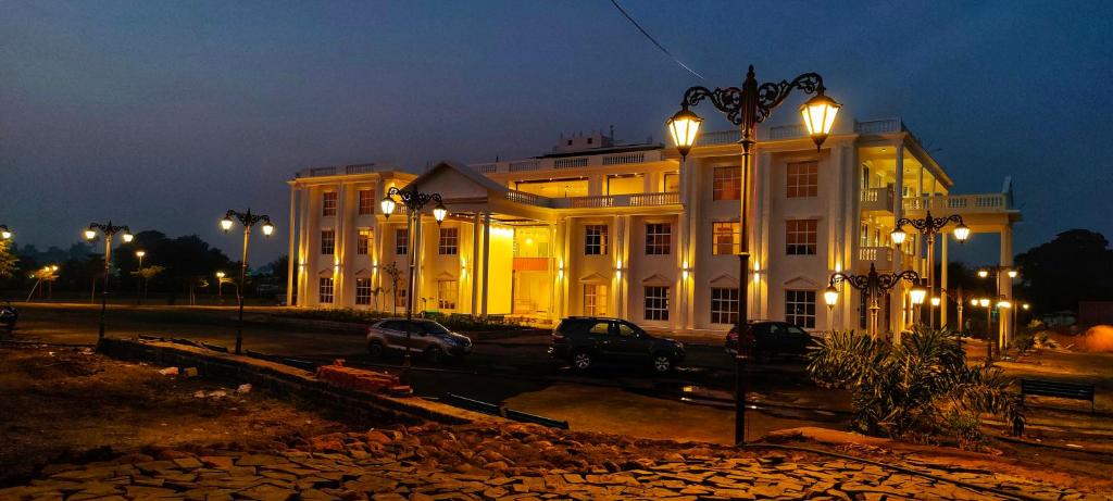 a large white building with lights on it at night at The Heritage Conventions in Sāgar