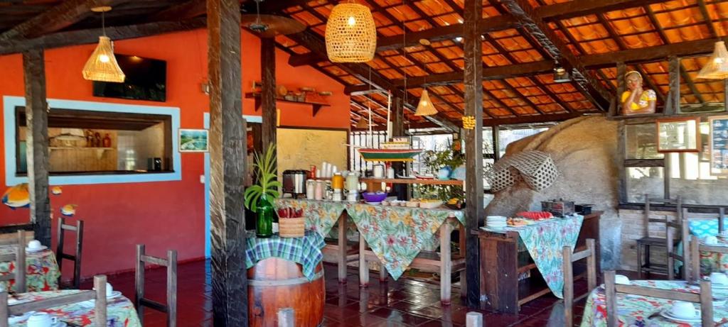 a restaurant with tables and chairs in a room at Pousada Por do Sol in Ilhabela