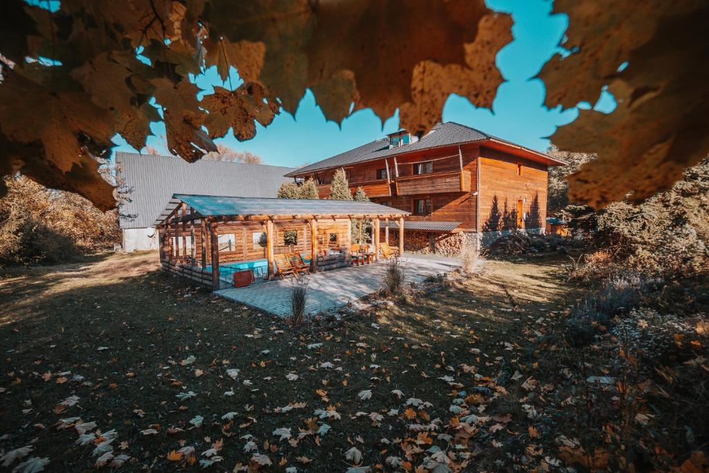 a large wooden house in front of a building at Pension Koliba Komorní Lhotka in Komorní Lhotka