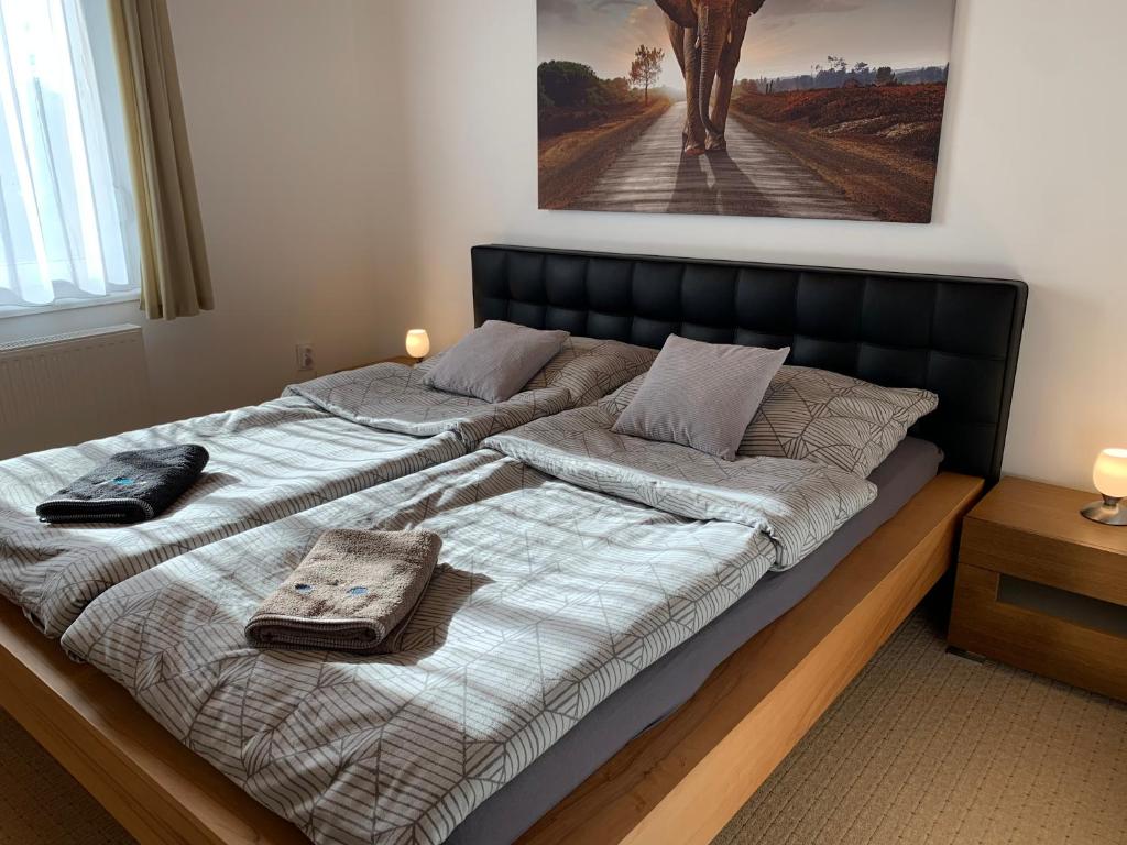 sypialnia z dużym łóżkiem z czarnym zagłówkiem w obiekcie Apartman TinaSol w mieście Mosonmagyaróvár