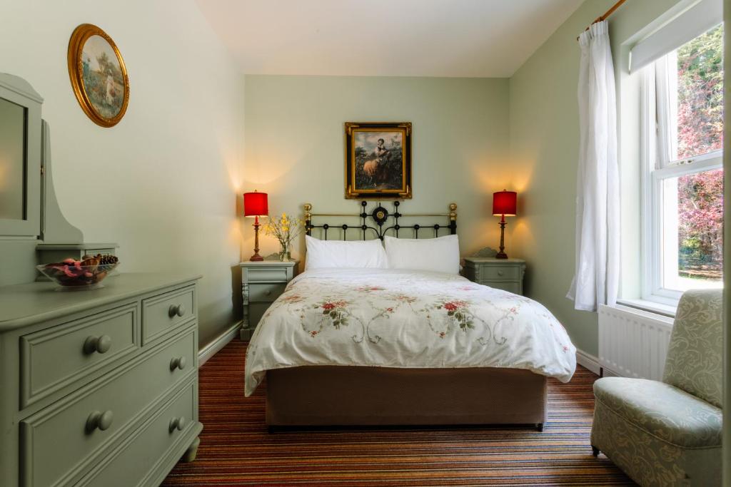 sypialnia z łóżkiem, 2 oknami i krzesłem w obiekcie Brookhall Cottages w mieście Lisburn