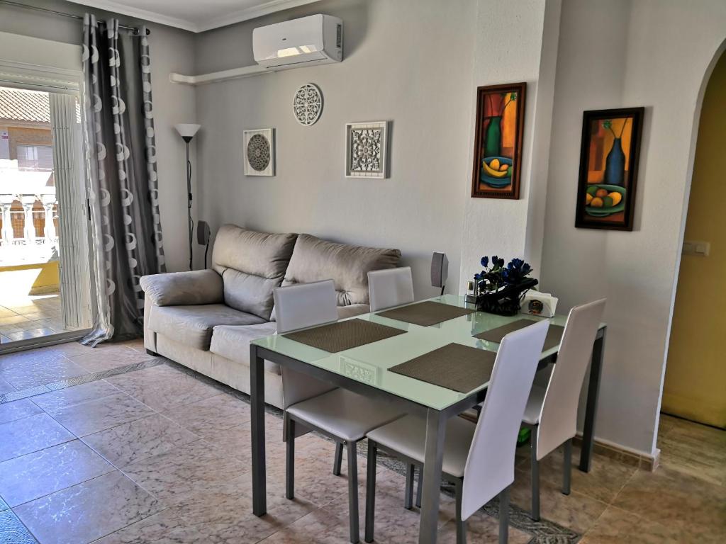 ein Esszimmer mit einem Tisch und einem Sofa in der Unterkunft Nice apartment in quiet area Aguas Nuevas in Torrevieja