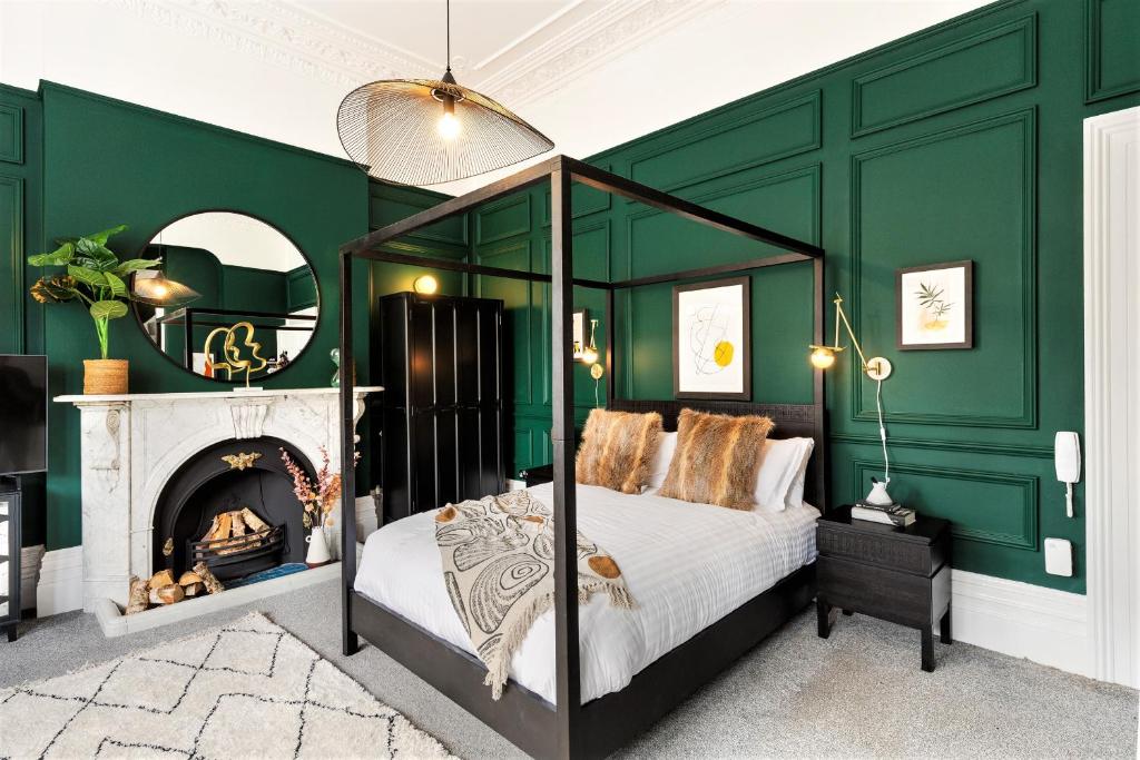a bedroom with green walls and a bed with a fireplace at Your Apartment I Clifton House in Bristol