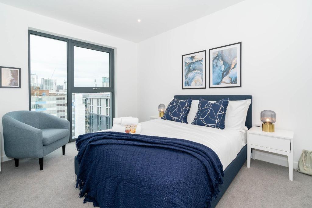 een slaapkamer met een bed, een stoel en een raam bij Deluxe 1 Bedroom Stylish Apartment - City Centre in Birmingham