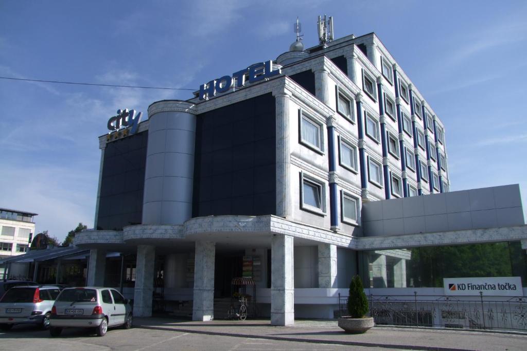 ein großes Gebäude mit davor geparkt in der Unterkunft City Hotel Krško in Krško