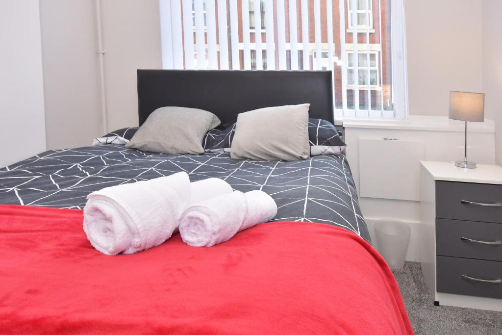 een bed met drie opgerolde handdoeken erop bij Townhouse @ Warrington Road Stoke in Etruria