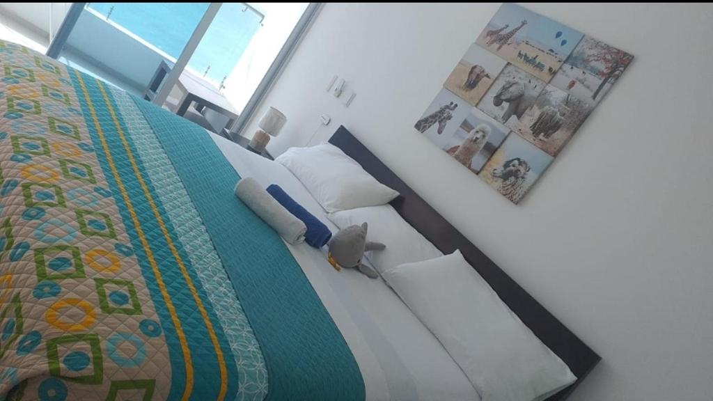 een slaapkamer met een bed met een quilt bij Departamento frente al mar Grand Diamond in Tonsupa