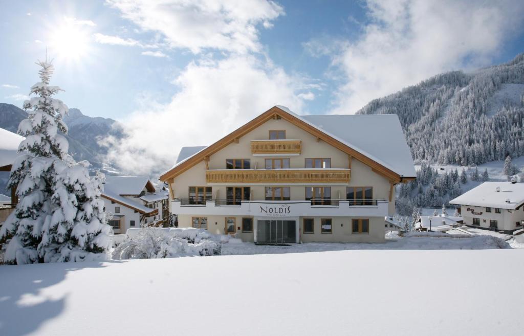 eine Skihütte im Schnee mit einem Weihnachtsbaum in der Unterkunft Noldis Hotel in Serfaus