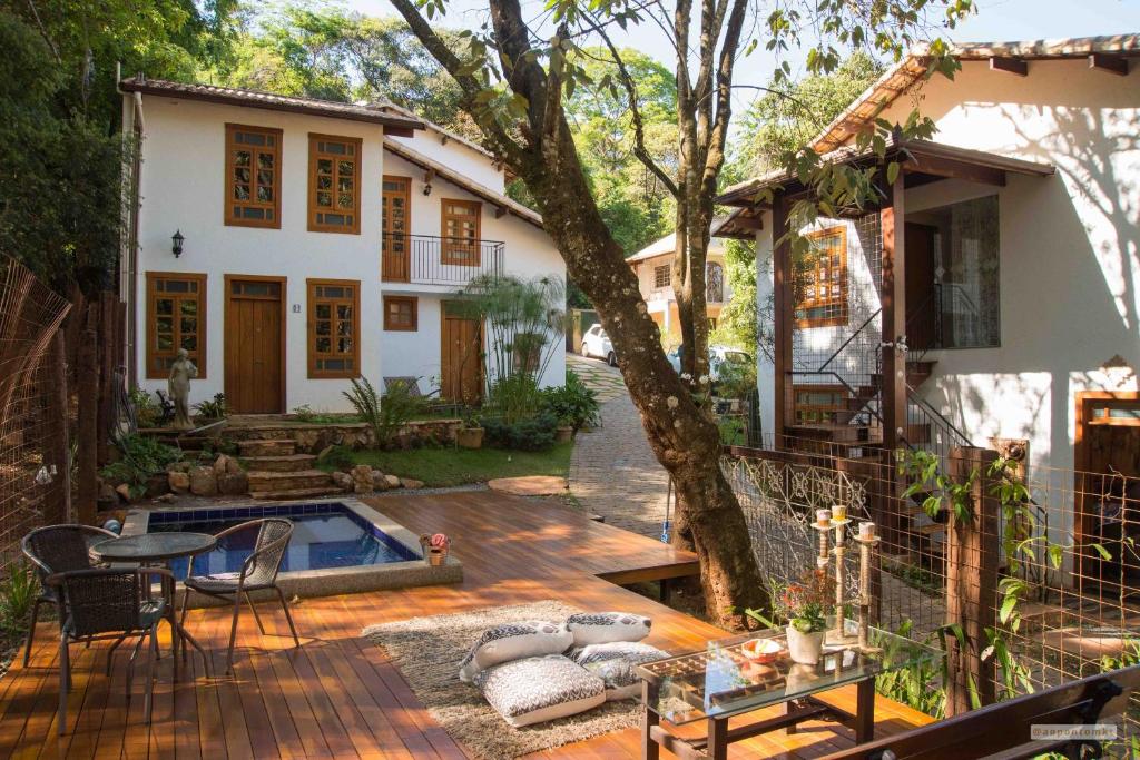 a house with a wooden deck and a patio area at Villa Rica Pousada Boutique in Brumadinho