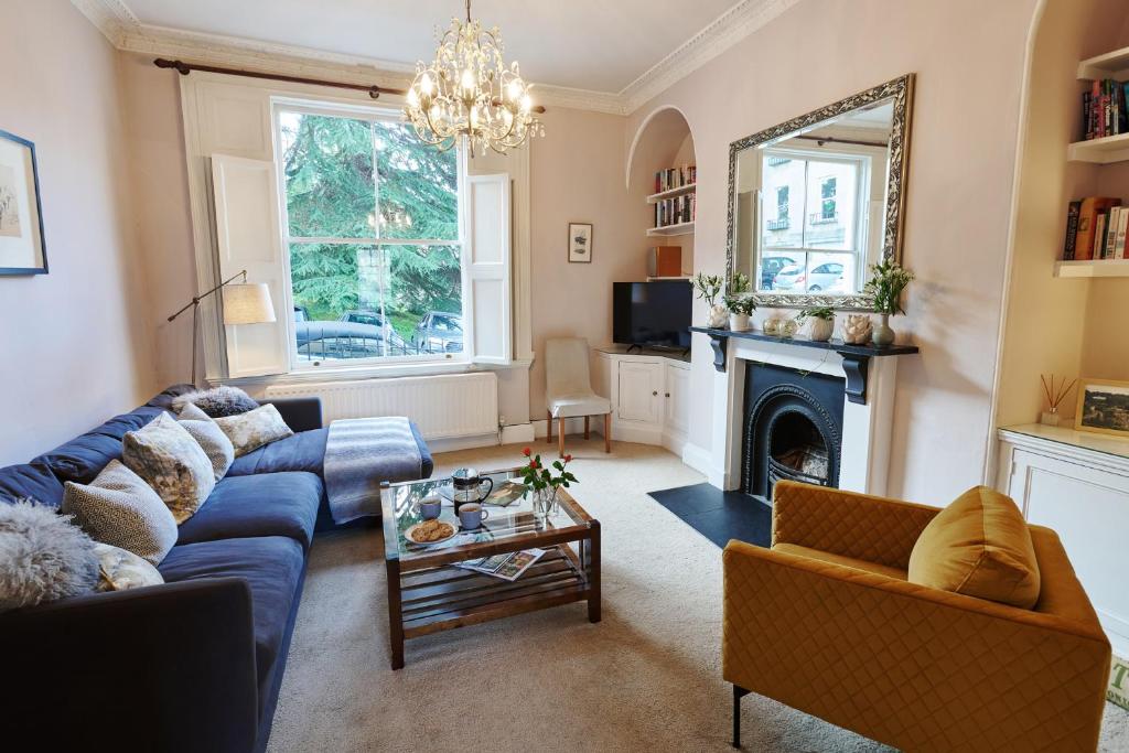 a living room with a blue couch and a fireplace at Southcot Place in Bath