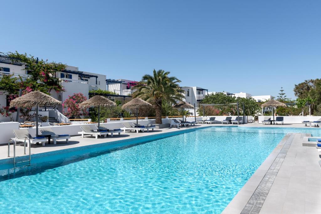 einen Pool mit Stühlen und Sonnenschirmen in einem Resort in der Unterkunft Rivari Santorini Hotel in Kamari