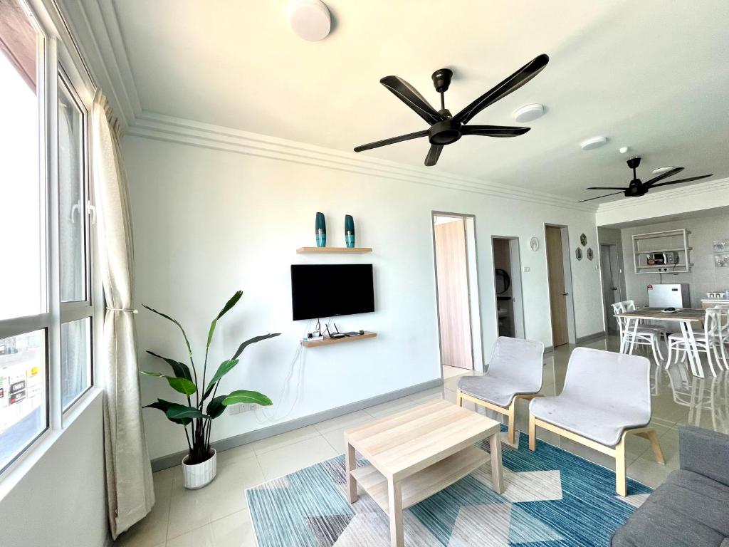 a living room with a ceiling fan and a tv at New Seaview Families Suite - Breezy Blue in Kuala Terengganu
