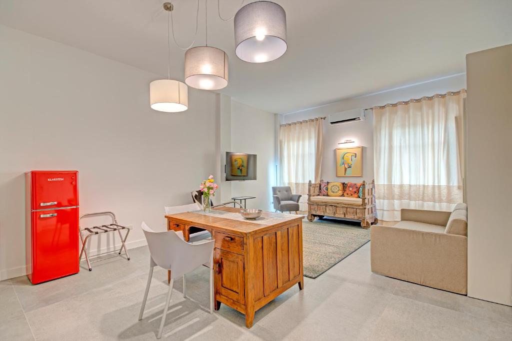 a living room with a table and a red refrigerator at Right House Sur le Port - Harbour View in Cagliari
