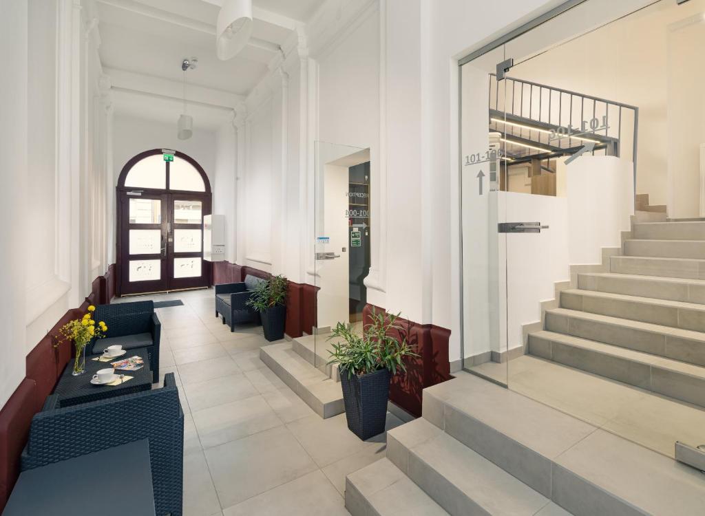 a lobby with stairs and a table and chairs at RES City Residence Hotel Budapest in Budapest
