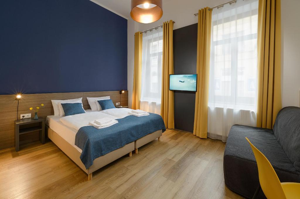 a bedroom with a bed and a couch at RES City Residence Hotel Budapest in Budapest