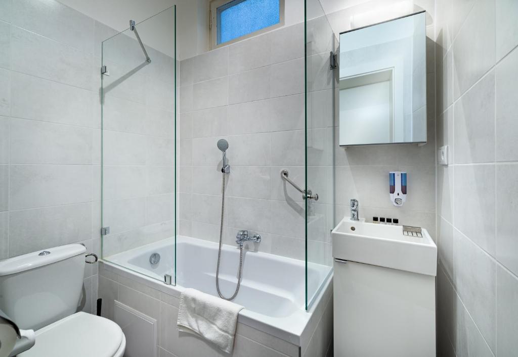 a bathroom with a toilet and a glass shower at RES City Residence Hotel Budapest in Budapest