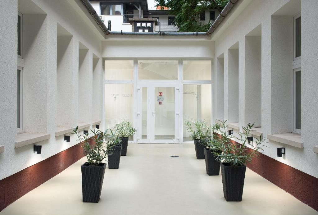 a row of potted plants in a hallway at RES City Residence Hotel Budapest in Budapest