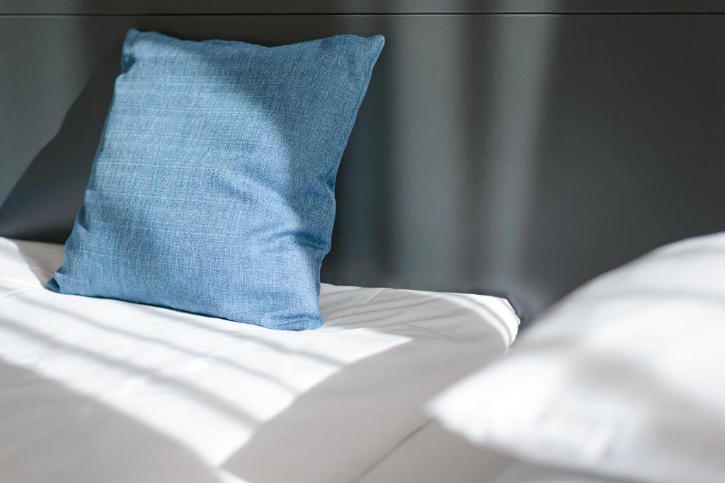 a blue pillow sitting on top of a bed at RES City Residence Hotel Budapest in Budapest