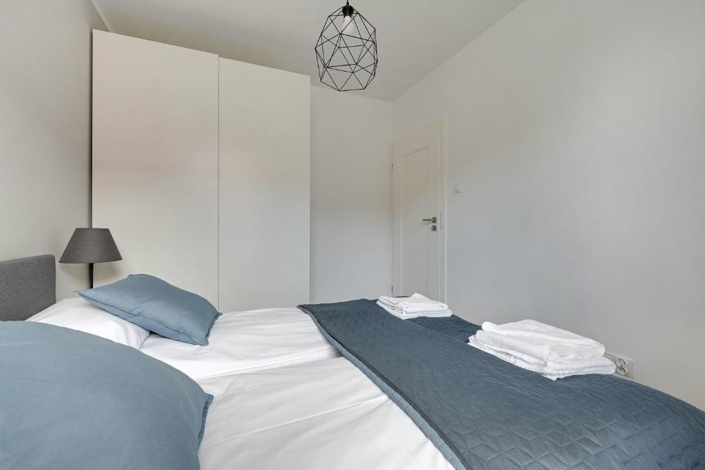 a bedroom with two beds with white and blue at Opal K2009 Grand - Tourist Apartments in Gdańsk