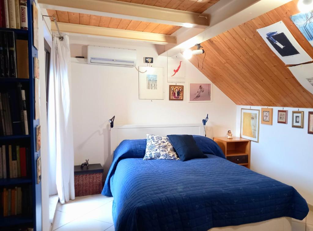 una camera da letto con letto blu in mansarda di TakeAmalfiCoast City Loft a Baronissi