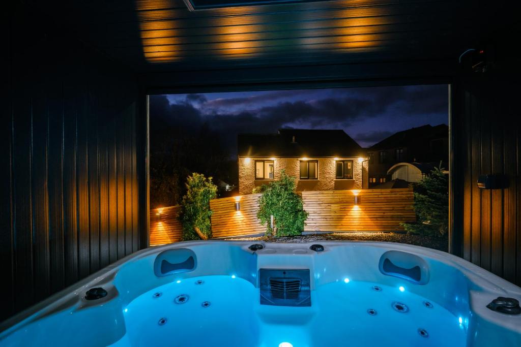 un jacuzzi en el patio trasero por la noche en Rockside - Luxury 1 bedroom home with hot tub central, parking pet friendly hot tub turns off 930pm, en Windermere