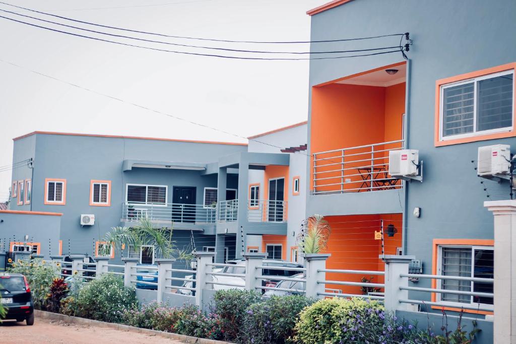 a row of houses with orange and blue at Aviation Highway Apartment in Spintex