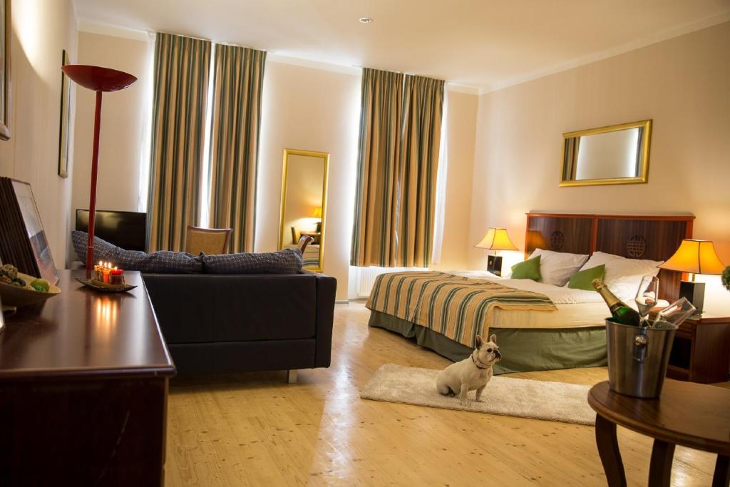 a bedroom with a bed and a dog sitting in a room at Apartmány Amethyst in Karlovy Vary