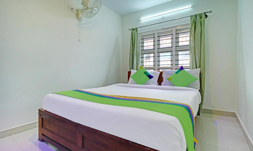 Postel nebo postele na pokoji v ubytování Treebo New Redfern, Madikeri