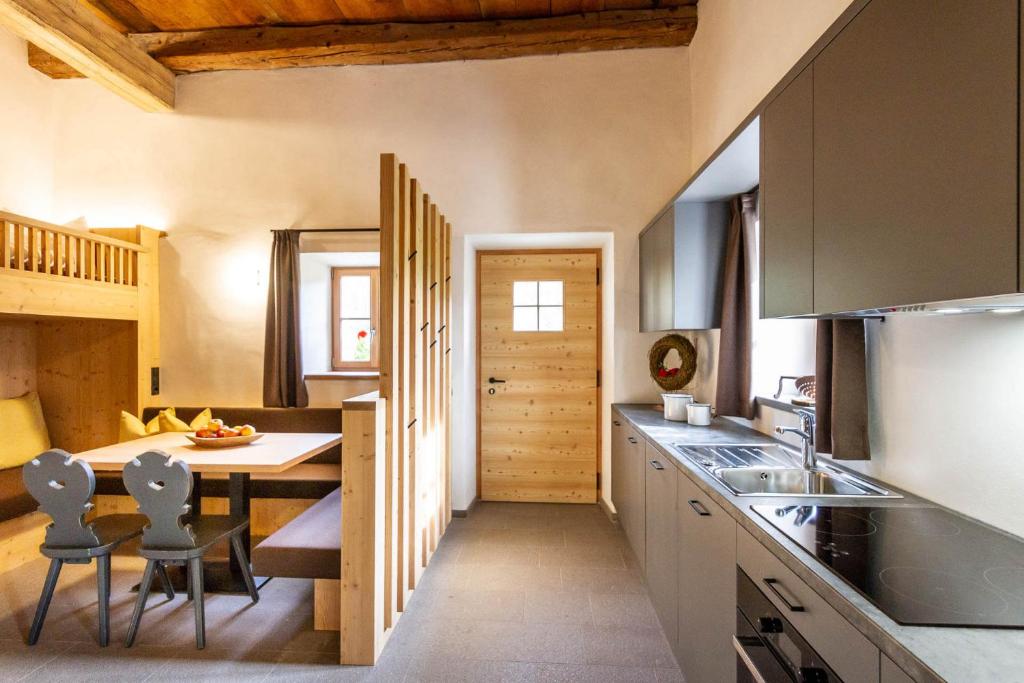 cocina con mesa y sillas en una habitación en Daimlhof Ferienwohnung Schlernstein en Fiè