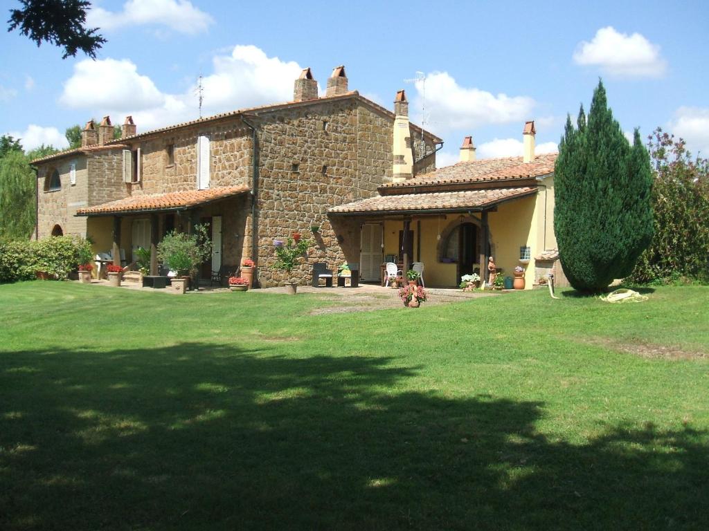 una gran casa de piedra con un perro en el patio en Poggio dell'Olivo, en Pitigliano
