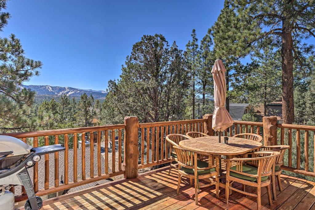a deck with a table and chairs and an umbrella at 4 Mi to Snow Summit Cabin with Mtn Views and Decks in Big Bear City