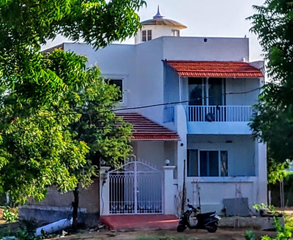 比卡內爾的住宿－Villa 51，前面有一辆摩托车停放的白色房子