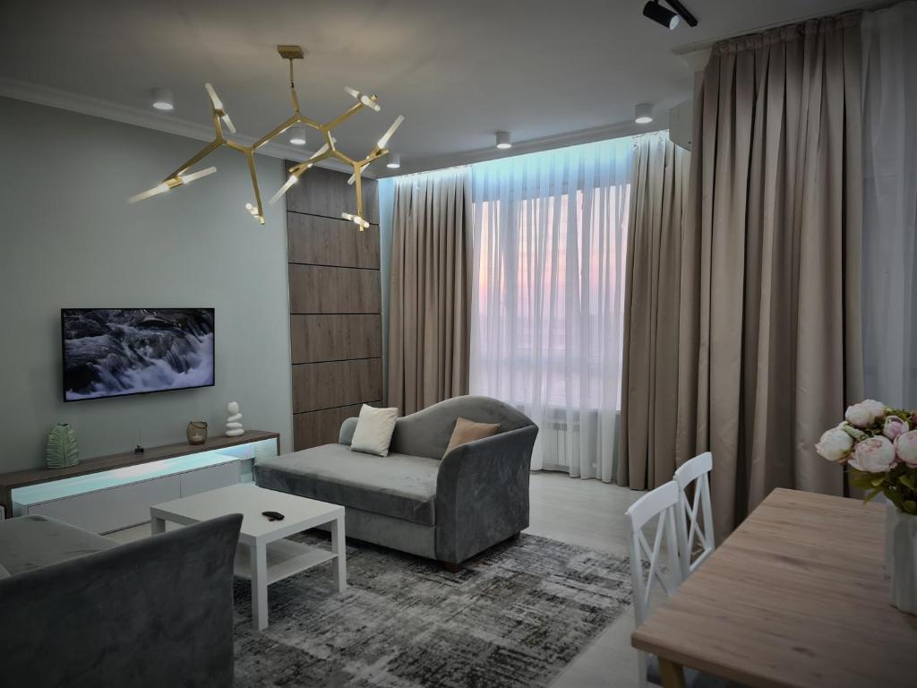 un soggiorno con divano e tavolo di Deluxe Apartment - Tamerlan Residence a Shymkent