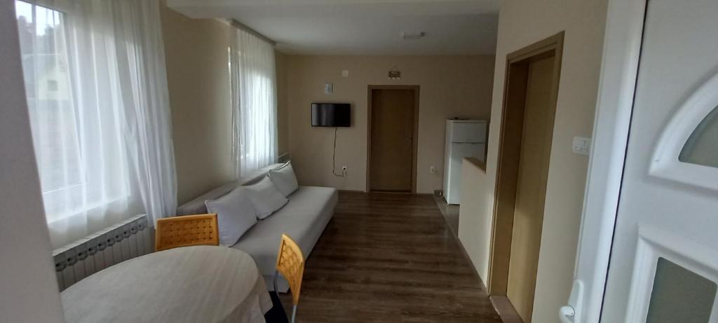 ein Wohnzimmer mit einer weißen Couch in einem Zimmer in der Unterkunft Apartman Narcis Polje in Divčibare