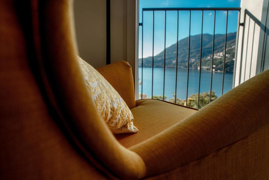 um sofá com uma almofada em frente a uma janela em An armchair on the Lake - Private parking for medium car em Blevio