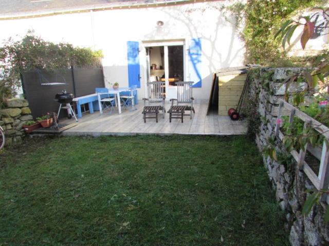 un patio con mesa, sillas y parrilla en Fisherman's cottage, en Ile d'Arz