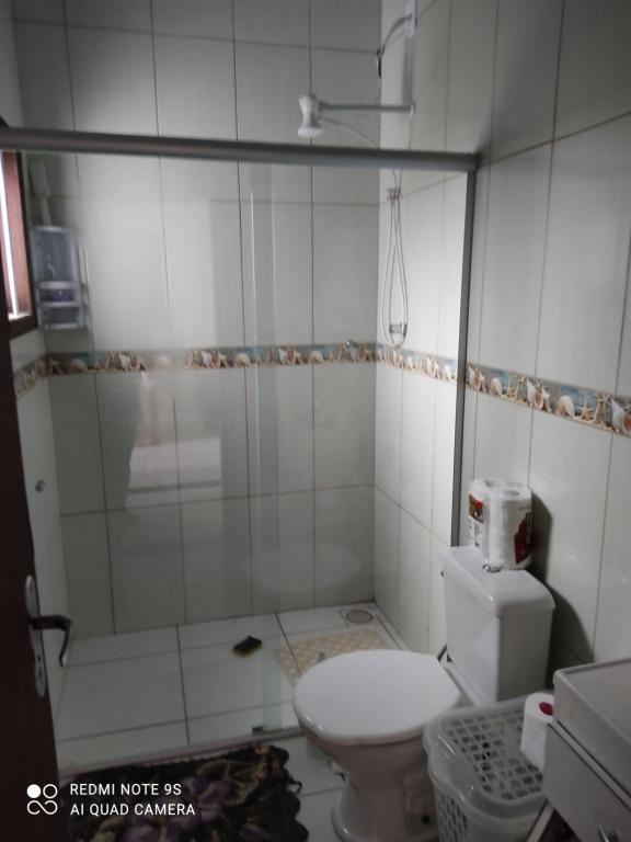 a small bathroom with a toilet and a shower at Paraíso tropical in Balneário Gaivotas
