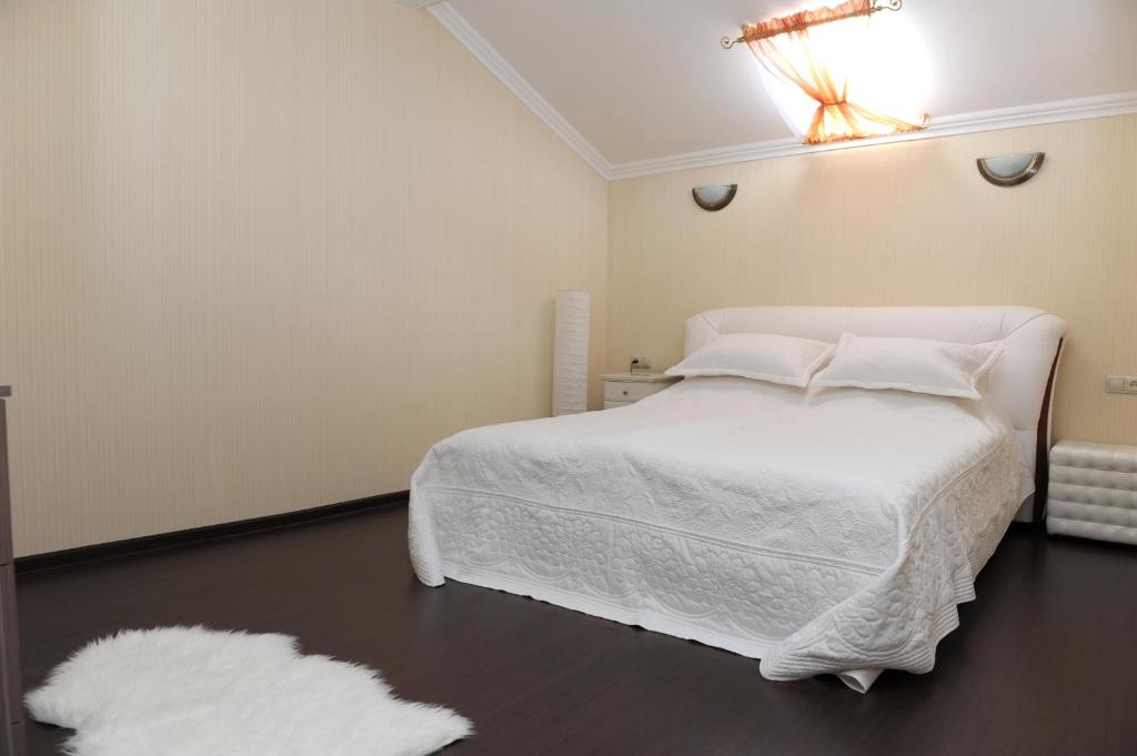 1 dormitorio con cama blanca y alfombra blanca en Hotel Mona Lisa, en Nizhny Novgorod