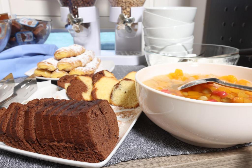 a table with a plate of bread and a bowl of soup at Summer Beach Hotel in Polychrono