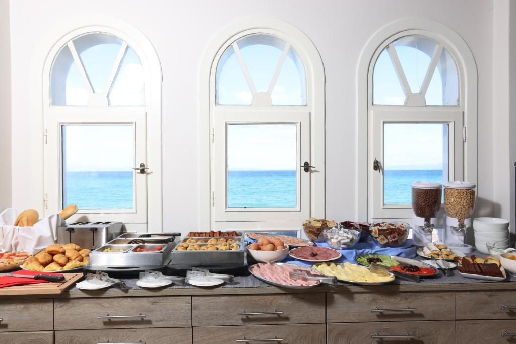a buffet of food on a table with windows at Summer Beach Hotel in Polychrono