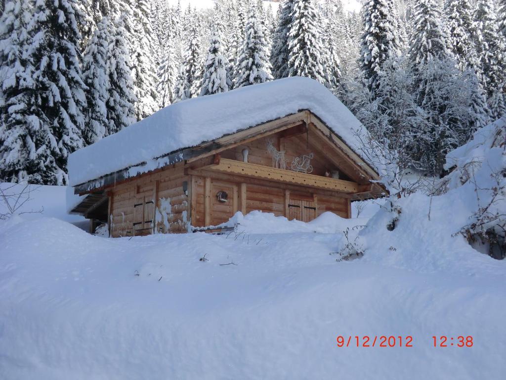 una baita di tronchi con neve sul tetto di Chalet Chardon a Morzine