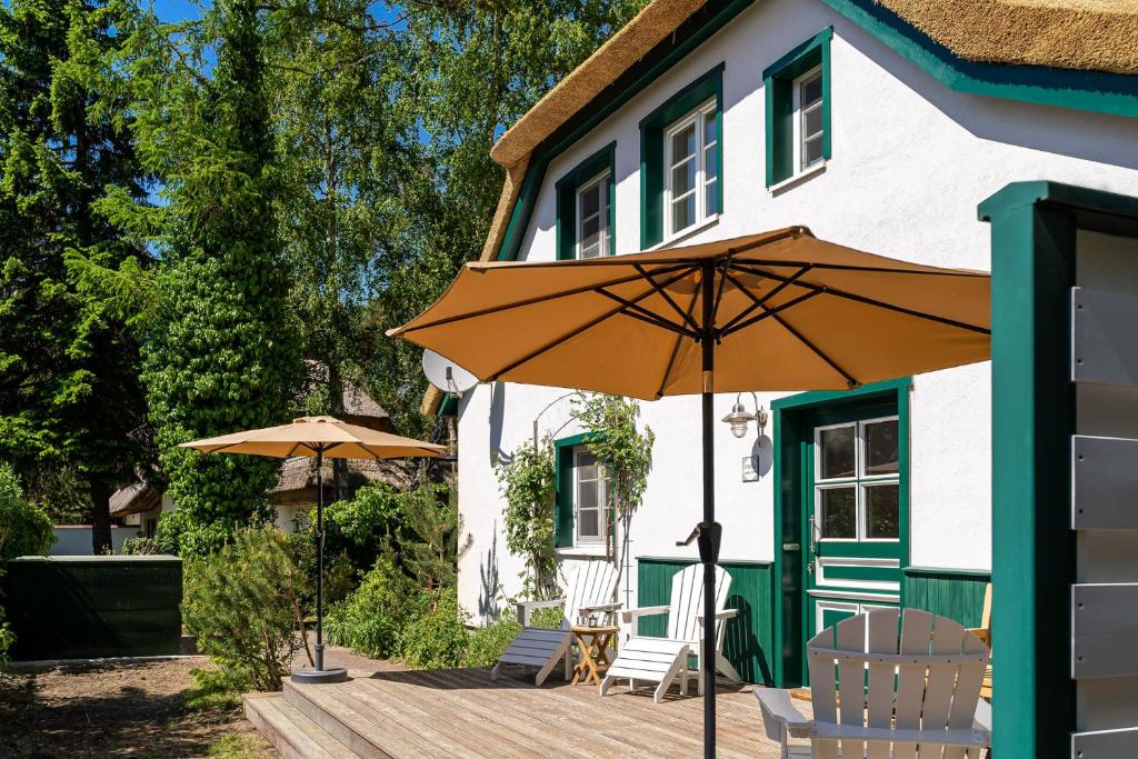an umbrella on a deck in front of a house at Strandhaus Düne 19 - Gelassenheit in Neuhaus