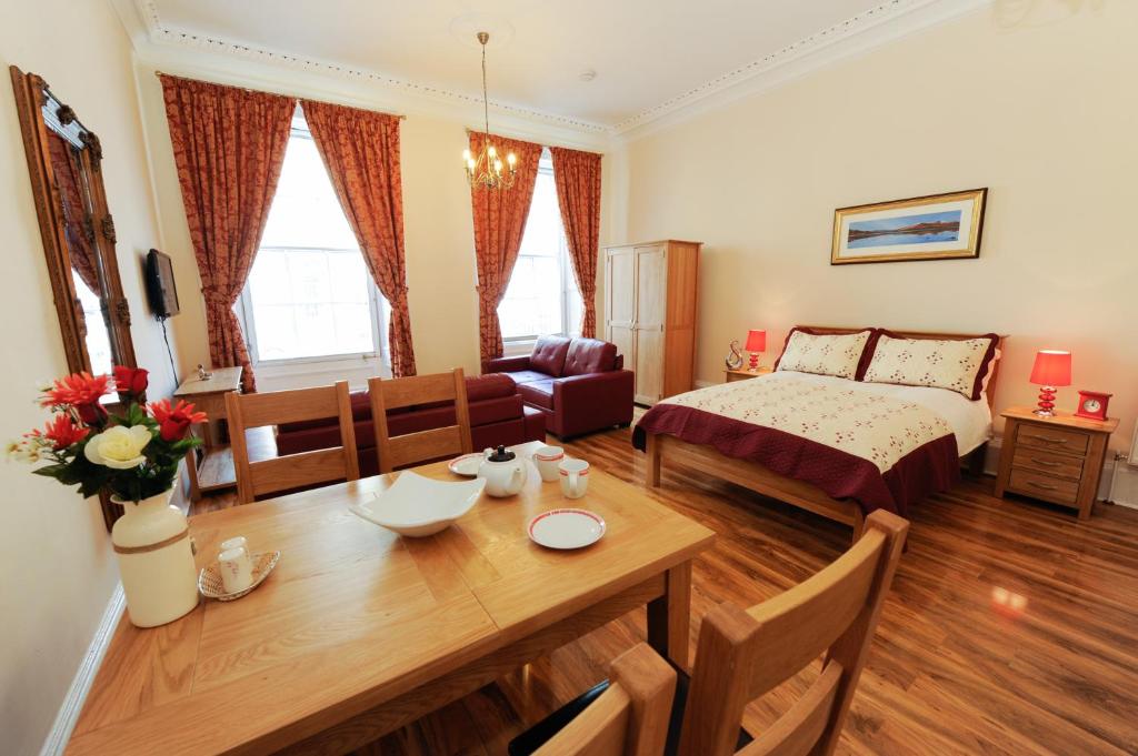 a living room with a bed and a dining room at Edinburgh City Suites in Edinburgh